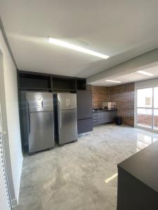 a large kitchen with stainless steel appliances in a room at Priority Praia grande in Praia Grande