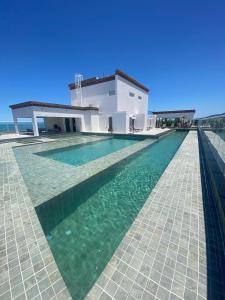 a swimming pool in front of a house at Priority Praia grande in Praia Grande