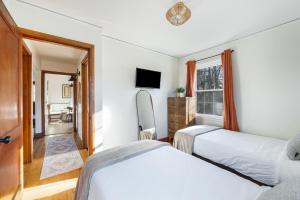 een slaapkamer met twee bedden, een tv en een raam bij Sage & Stone Cottage in Lynchburg