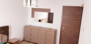 een slaapkamer met een dressoir en een spiegel bij ApartDecebal in Craiova