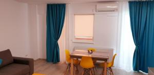 een woonkamer met een tafel en wat blauwe gordijnen bij ApartDecebal in Craiova +7 foto's