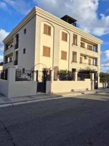 un edificio bianco con una recinzione di fronte a una strada di Pascoli Apartment - Pula a Pula