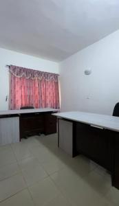 een lege kamer met een bureau en een raam bij Maison Ophir - Villa basse moderne in Cotonou