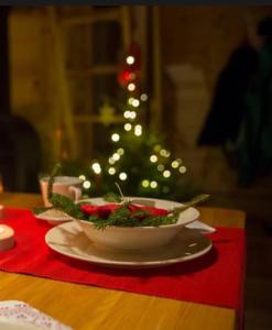 uma tigela de comida em uma mesa com uma árvore de natal em Domki KOLONIA LEŚNA z sauną i gorącą balią em Radków