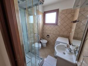 un bagno con doccia, lavandino e WC di Pascoli Apartment - Pula a Pula