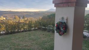 蒙特普齐亚诺ESSENZA di TOSCANA apartment with view的建筑物侧面挂着一个花圈。 更多17张照片