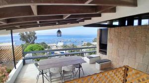 a patio with a wooden table and chairs on a balcony at Tongoy Bauhaus - Alojamiento hasta 12 personas in Tongoy