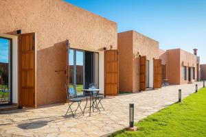 a building with a table and chairs in front of it at Dar Fatma Charming Moroccan Guesthouse with Pool & Hammam in Sidi Bibi