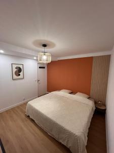 sypialnia z dużym łóżkiem i żyrandolem w obiekcie Logement autonome pour 2 à 4 personnes w mieście Poitiers