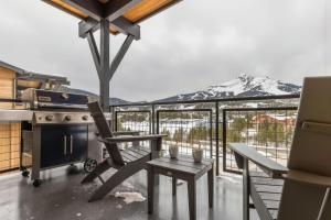 大天山村Big Sky Getaway Lone Peak Views Shared Hot Tub的阳台上有炉子，远处是山。