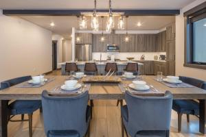大天山村Big Sky Getaway Lone Peak Views Shared Hot Tub的有一张大桌子和几把椅子的餐厅