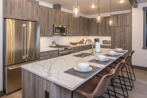 大天山村Big Sky Getaway Lone Peak Views Shared Hot Tub的厨房设有大岛,厨房配有不锈钢用具