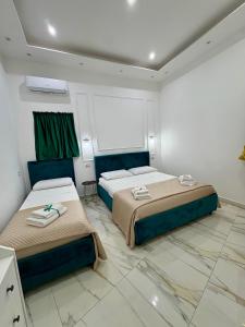 una camera da letto con due letti in una stanza di Sasy Home a Napoli