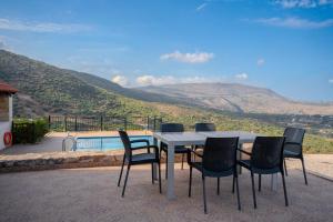 uma mesa e cadeiras com vista para uma piscina em Villa Petra em Kalyves