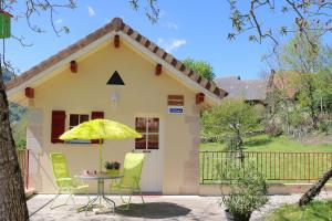 a small yellow house with a table and chairs at La Roche Bleue in Saint-Bois