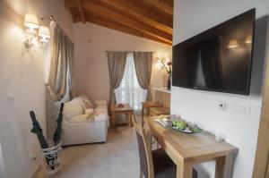 a living room with a table and a television on a wall at Holiday home My House in Mokošica