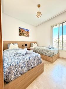 a bedroom with two beds and a window at Charmante maison de vacances proche de la plage à quelques minutes de Rabat in Temara