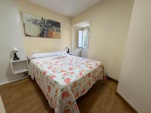 a bedroom with a bed with a floral bedspread at SP 43 Vut in Lugo