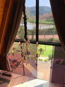 a room with a large window with a chandelier at Cabana Amélia, em Gramado in Gramado +57 photos