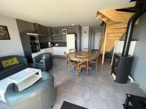 una cucina e un soggiorno con tavolo e piano cottura di Villa Residence Kersaliou a Roscoff