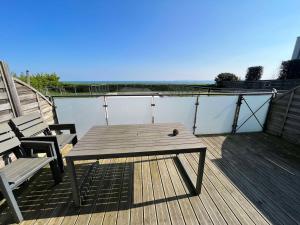 un tavolo in legno e 2 sedie su una terrazza di Villa Residence Kersaliou a Roscoff