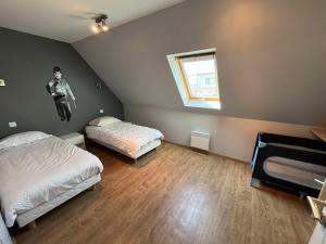 una camera da letto con due letti e un uomo che salta sul muro di Villa Residence Kersaliou a Roscoff