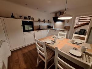a kitchen with a table and chairs in a room at S & C Ferienhaus in Oberbettingen