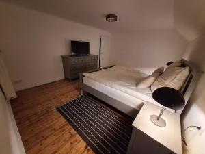 a bedroom with a bed with a desk and a television at S & C Ferienhaus in Oberbettingen