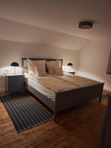 a bedroom with a large bed with two tables and two lamps at S & C Ferienhaus in Oberbettingen