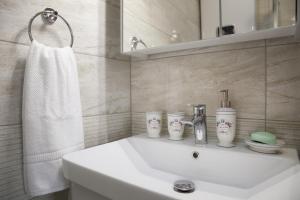 a white bathroom with a sink and a mirror at Holiday home My House in Mokošica +28 photos