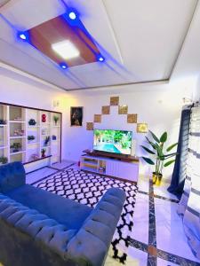 a living room with a blue couch and a tv at Résidence de la Paix in Yaoundé