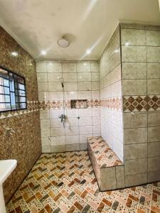 a bathroom with a shower and a sink at Résidence de la Paix in Yaoundé