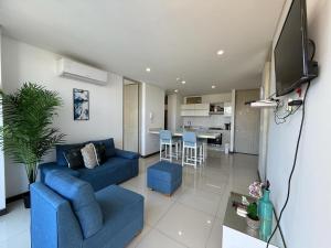ein Wohnzimmer mit einer blauen Couch und einem Fernseher in der Unterkunft Edificio Ocean Club in Santa Marta