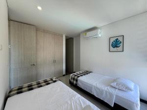 ein Schlafzimmer mit zwei Betten in einem Zimmer in der Unterkunft Edificio Ocean Club in Santa Marta + 38 Fotos