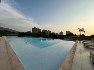 ein großes Schwimmbad mit einer Stadt im Hintergrund in der Unterkunft Edificio Ocean Club in Santa Marta