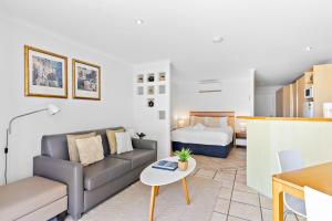a living room with a couch and a bed at At The Sound Noosa in Noosaville