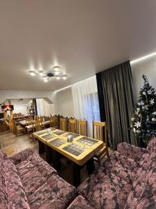 een eetkamer met een tafel en een kerstboom bij Садиба "Hutsulyana" in Dobrovelychkivka