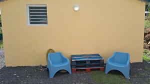two blue chairs and a table next to a building at Sapotille sucrée in Sainte-Rose