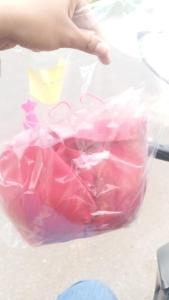 a person holding a plastic container filled with pink items at Descanso merecido in Goiânia