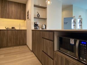 a kitchen with wooden cabinets and a microwave at Modern 2BR with Balcony in San Isidro in Lima