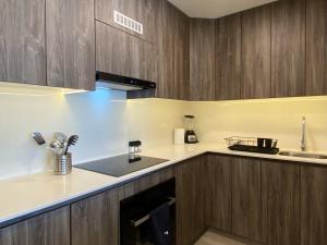 a kitchen with wooden cabinets and a counter top at Modern 2BR with Balcony in San Isidro in Lima