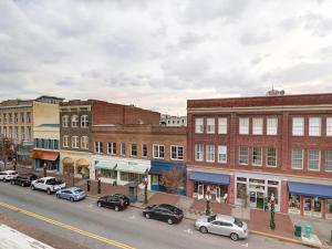 uma rua da cidade com carros estacionados em frente aos edifícios em Above Broughton St 3002 em Savannah