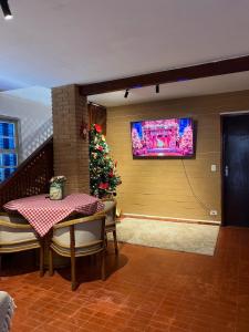 Pousada Sonho Meu - Conforto e Tranquilidade! في كامبوس دو جورداو: غرفة بها طاولة وشجرة عيد الميلاد على الحائط