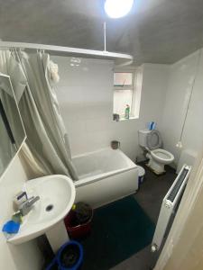 a bathroom with a tub and a sink and a toilet at EAST HAM HOME SHARe in London
