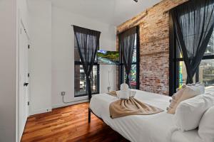 a bedroom with a white bed and a brick wall at The Founders Suite Residence in Philadelphia