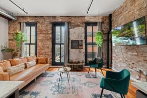 an exposed brick wall in a living room with a couch and chairs at The Founders Suite Residence in Philadelphia