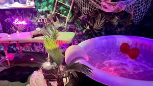 a hot tub in a room with purple lighting at Un Mirage Tropical - Bulles , Spa & Détente en Bord de Loire in Saint-Clément-des-Levées