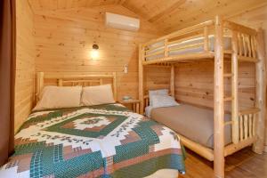 a bedroom with two bunk beds in a log cabin at Shared Dock Access at Lakeside Sodus Bay Cabin! in North Rose