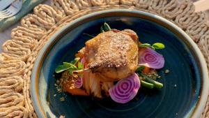 a blue plate with a piece of chicken with vegetables at Sal Salis Ningaloo Reef in Exmouth
