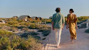 a man and woman walking down a dirt road at Sal Salis Ningaloo Reef in Exmouth